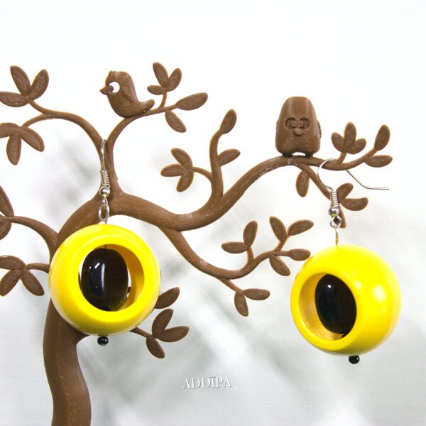 Yellow earrings with a black glass bead.
